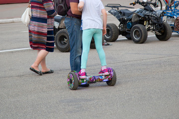 Girl on a scooter riding on the street. © Александр Поташев