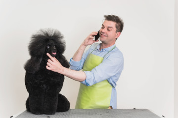 Groomer talking on a phone with client