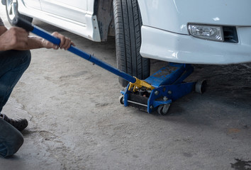 Hydraulic car jack to lift car for check the wheel.