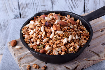 Homemade granola with various nuts and seeds in a cast iron pan