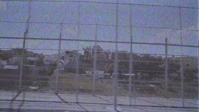 Ceuta, Spain VHS vintage film tape effect on footage of double barbed wire fence at Moroccan border meant to stop migrant inflows into EU, pushback action at border