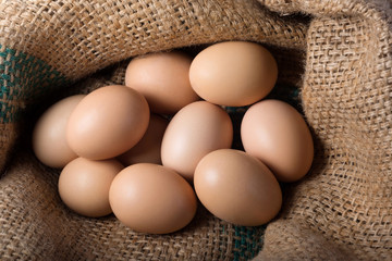 Ten brown, eggs on burlap. Top view. Poultry farm, protein.