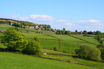 Naklejka premium selective focus view of the village of midgley in west yorkshire with surrounding green fields and farmhouses in a spring pennine landscape