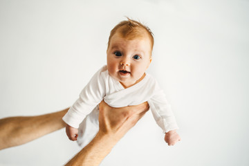 Father hands holding infant baby family lifestyle dad and child parenthood concept 3 month old kid
