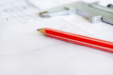 Caliper and red pencil are on the drawing, after the technical project.