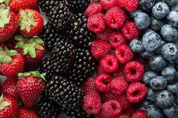 Fresh Summer Berries mix Background with Strawberry, Raspberry, Red currant, Blueberry and Blackberry.