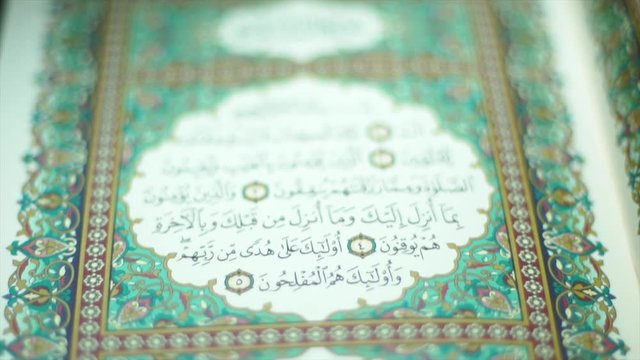 the holy Quran muslim holy book, detail of surah in slow motion 