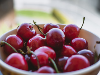 Red cherries in a bowl close-up
