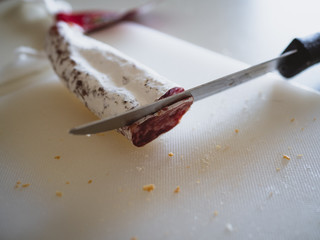 Spanish fuet sausage being cut in slices