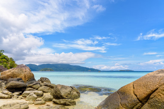 Beautiful tropics nature landscape of clear sea, beach, rocks and clouds on blue sky in the summer at Ko Ra Wi, See the Ko Adang in front near Koh Lipe island Tarutao National Park, Thailand
