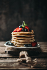 American pancakes with fresh berry on wood background. Summer homemade breakfast.