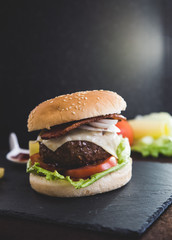 Delicious burgers with beef patty, bacon, cheese and cabbage