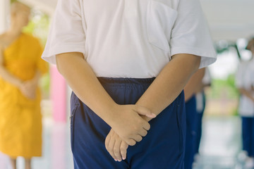 Group of students try to meditate for the peace of mind by walk with Buddhist monk in school.