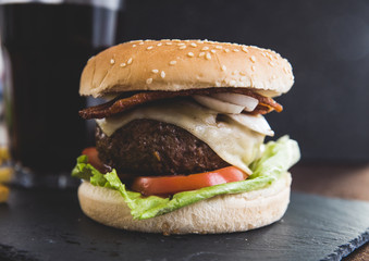 Delicious burgers with beef patty, bacon, cheese and cabbage