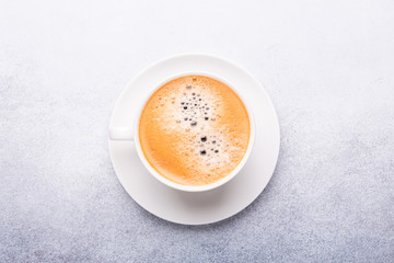 Cup of coffee on stone background. Office workplace. Top view