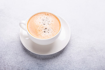 Cup of coffee on stone background. Office workplace. Top view