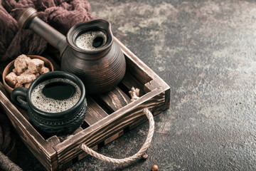 Coffee on wooden tray with coffee beans on dark textured background. Top view with copy space. Background with free text space.