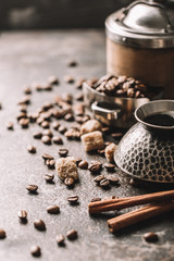 Coffee cup and coffee beans on dark stone background.
