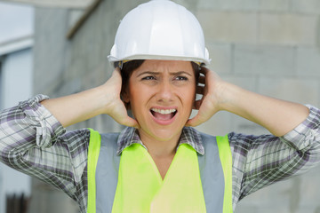 engineer construction worker woman covering ears ignoring loud noise