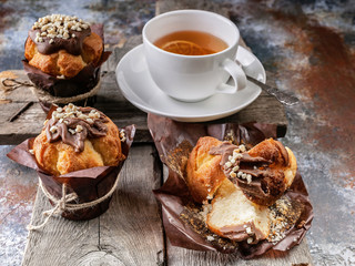Homemade muffins and flavored tea on a rustic wooden background. Close-up