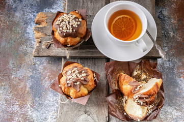Homemade muffins and flavored tea on a rustic wooden background. Close-up. Top view