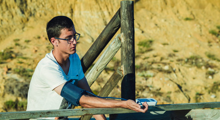Hypertensive patient performing an automatic blood pressure test on the outside