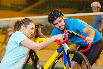 Naklejka premium female bicycle technician mending the cyclist bike
