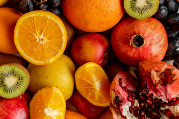 Naklejka na ściany i meble abstract background with fresh organic fruits such as sliced orange kiwi grapes and garnets