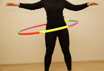 Female is hula-hooping. Home trainings concept. Workout at home. Healthy lifestyle. 