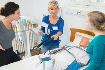 nurses lifting a dummy on bed - obrazy, fototapety, plakaty