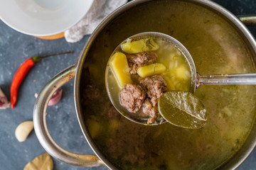 top view of boiling hot steaming soup with vegetables and meat, food preparation before a dinners