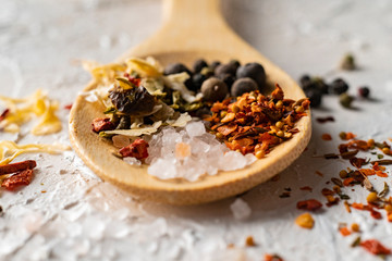 close up large wooden spoon with aromatic mix of peppers herbs and spices, indian culinarys