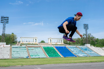 young man athlete practice high jump fly in the air at the stadium on a summer days