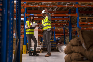Warehouse managers in large storage department controlling distribution to the market.