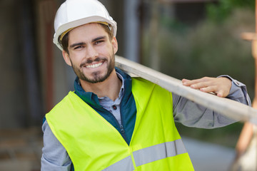 man as builder carrying wood and working