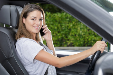 Fototapeta na wymiar beautiful woman talking on phone while driving