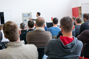Fototapeta premium Audience at business presentation listening to person giving a speach.