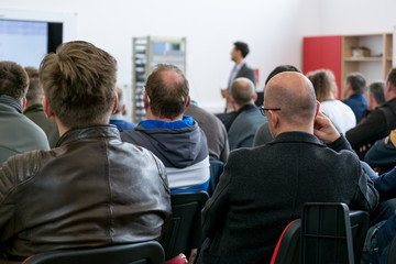 Fototapeta premium Audience at business presentation listening to person giving a speach.
