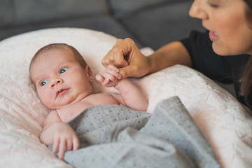 Happy mother giving cuddles and playing smiling with her cute newborn. Family, new life, childhood,...