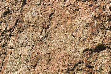 Background of granite. Texture of granite stone. Pattern of roughened surface. Texture of brown stone