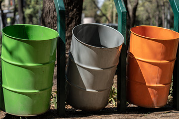 hree different waste bins in a public park	