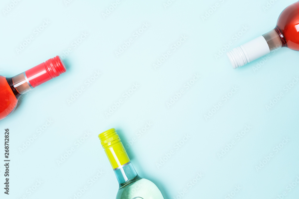 Wall mural layout frame of foil caps in different bright colors of white and rose wine bottles on blue backgrou