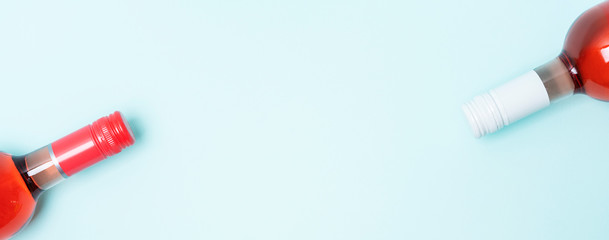 Colorful bottle caps of white and rose wine bottles on turquoise background. Minimal abstract colorful layout concept of summer time alcohol beverage. Long wide banner.