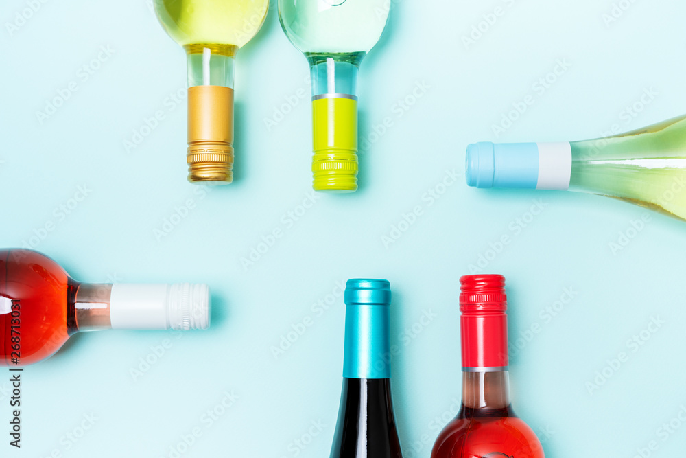 Wall mural layout frame of foil caps in different bright colors of white and rose wine bottles on blue backgrou