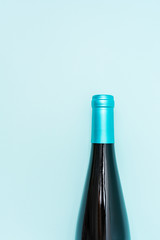 Screw bottle foil caps in different bright colors of white and rose wine bottles on blue background with copy space. Minimal abstract colorful mockup concept of alcohol beverage. Flat lay.