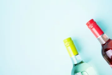 Foto auf Alu-Dibond Screw bottle foil caps in different bright colors of white and rose wine bottles on blue background with copy space. Minimal abstract colorful mockup concept of alcohol beverage. Flat lay. © PINKASEVICH