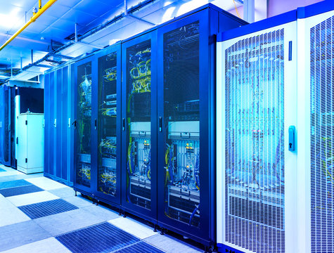 Server room with control modules in racks datacenter under blue toning - Powered by Adobe