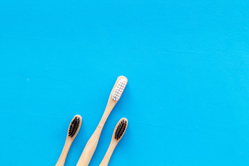 Dental care with eco friendly bamboo tooth brush on blue background top view space for text