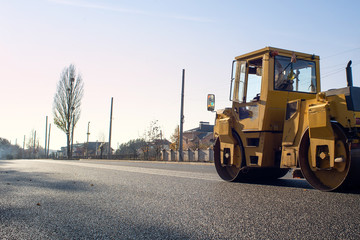 Close view on the asphalting machines. The big roller aligns asphalt for the new road