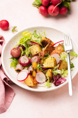 Tasty vegetarian summer salad with roasted potatoes, radishes and green salad leaf